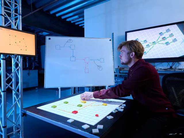 A colleague testing a routing prototype on a gridded board